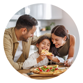 Family enjoying pizza meal together, smiling happily.
